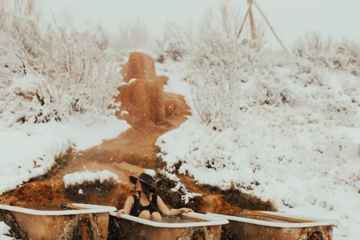 woman soaking in hot springs in the snow