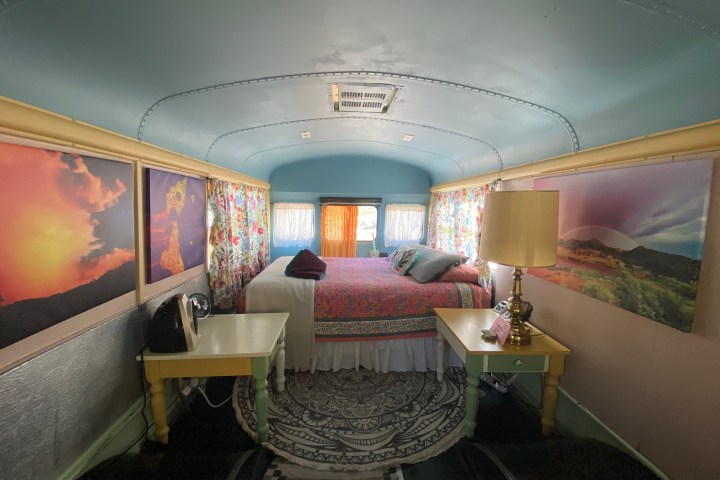 a bedroom with a bed and a chair in a room